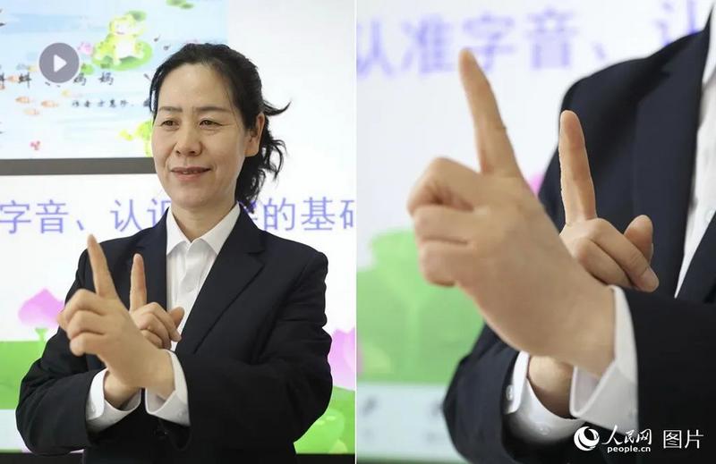 王艳老师用手语为听障学生讲授《小蝌蚪找妈妈》一课，妈妈陪在它们身边，手势意为“陪”。人民网记者 周博摄