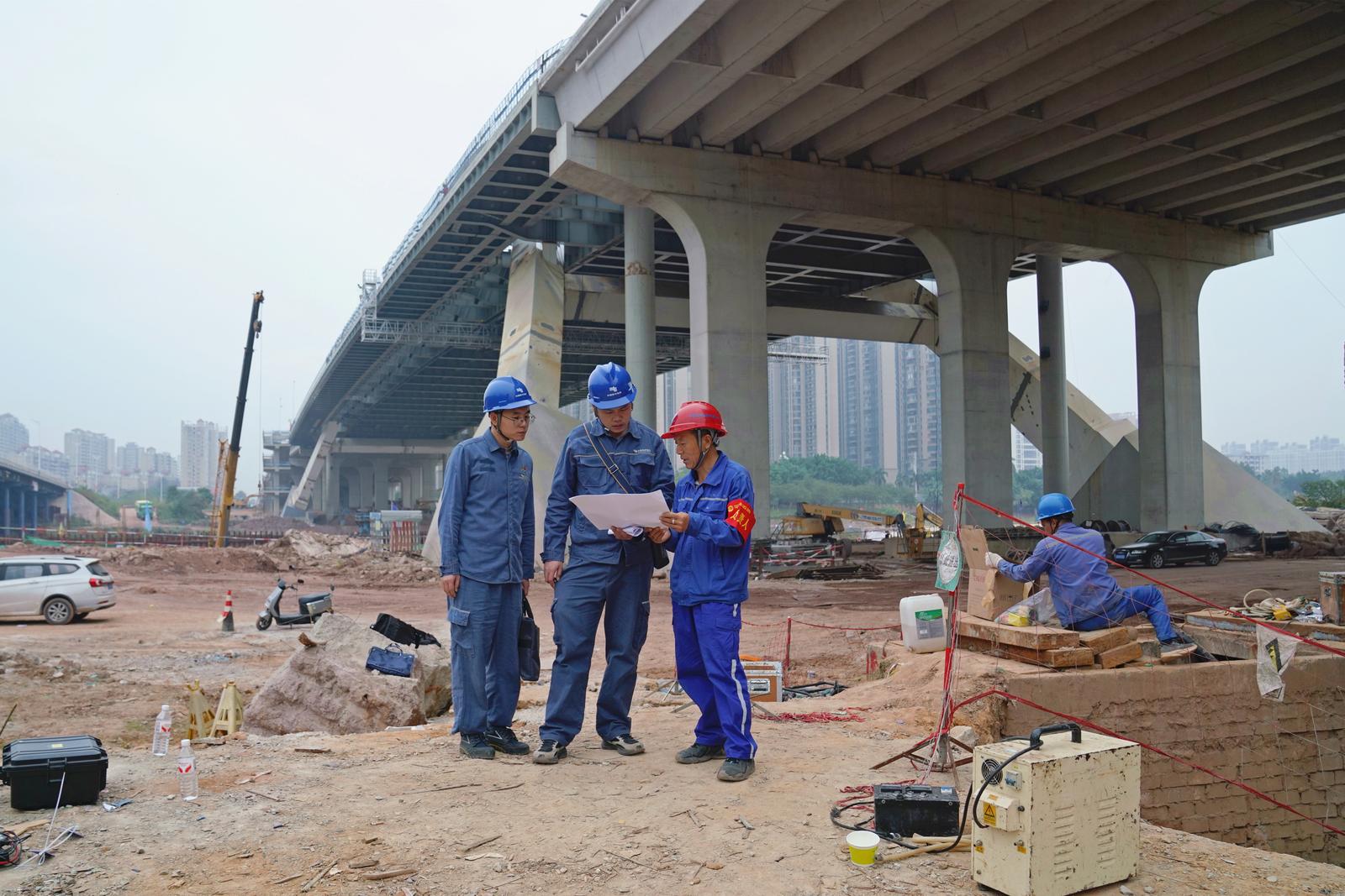 2025年12月11日,南方电网广西钦州供电局城区供电分局工作人员与平陆运河建设相关施工方在永福大桥跨运河线路迁改现场商议送电事宜。翟晋升 摄